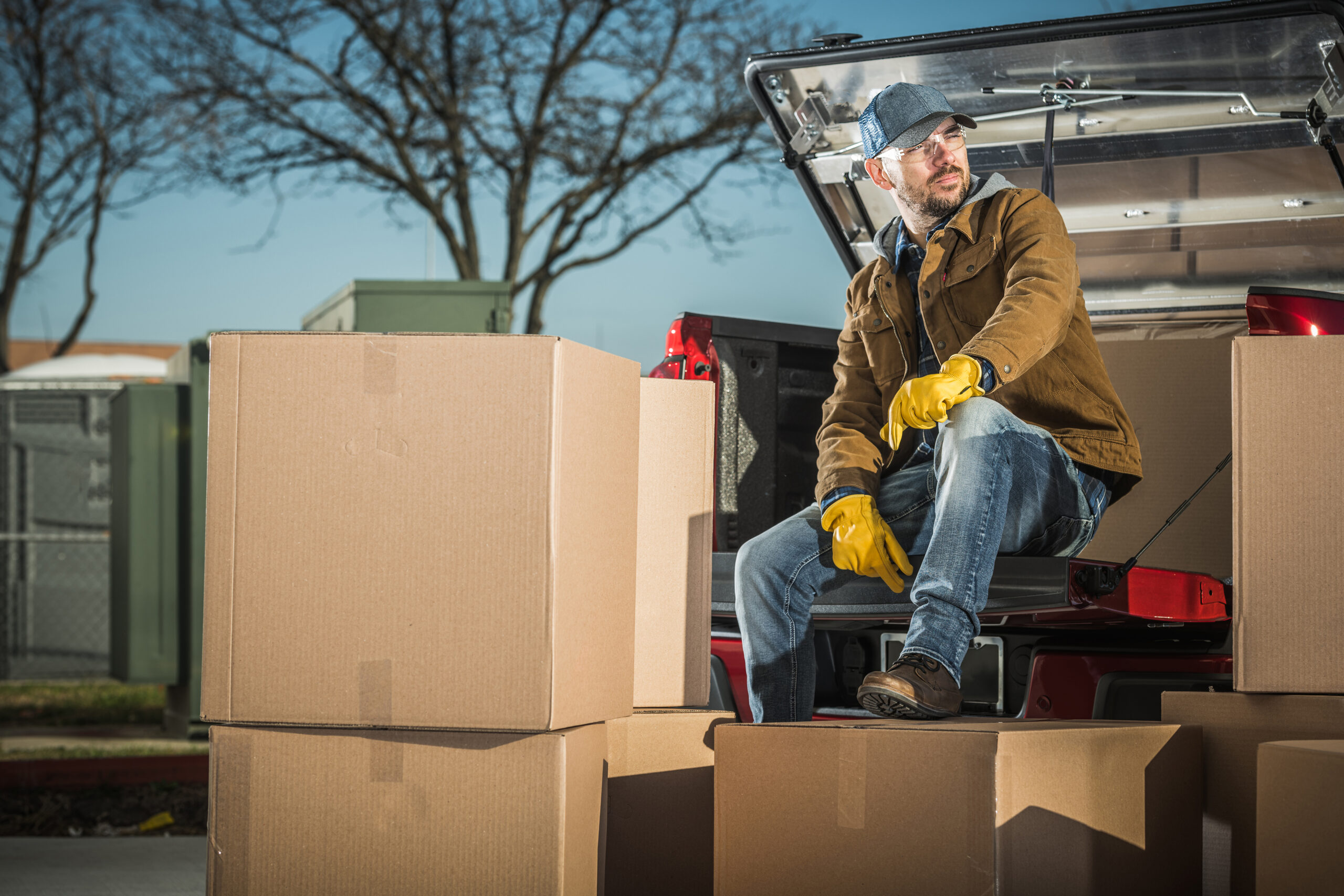 Courier Unloading Shipping Boxes Parcel From His Truck