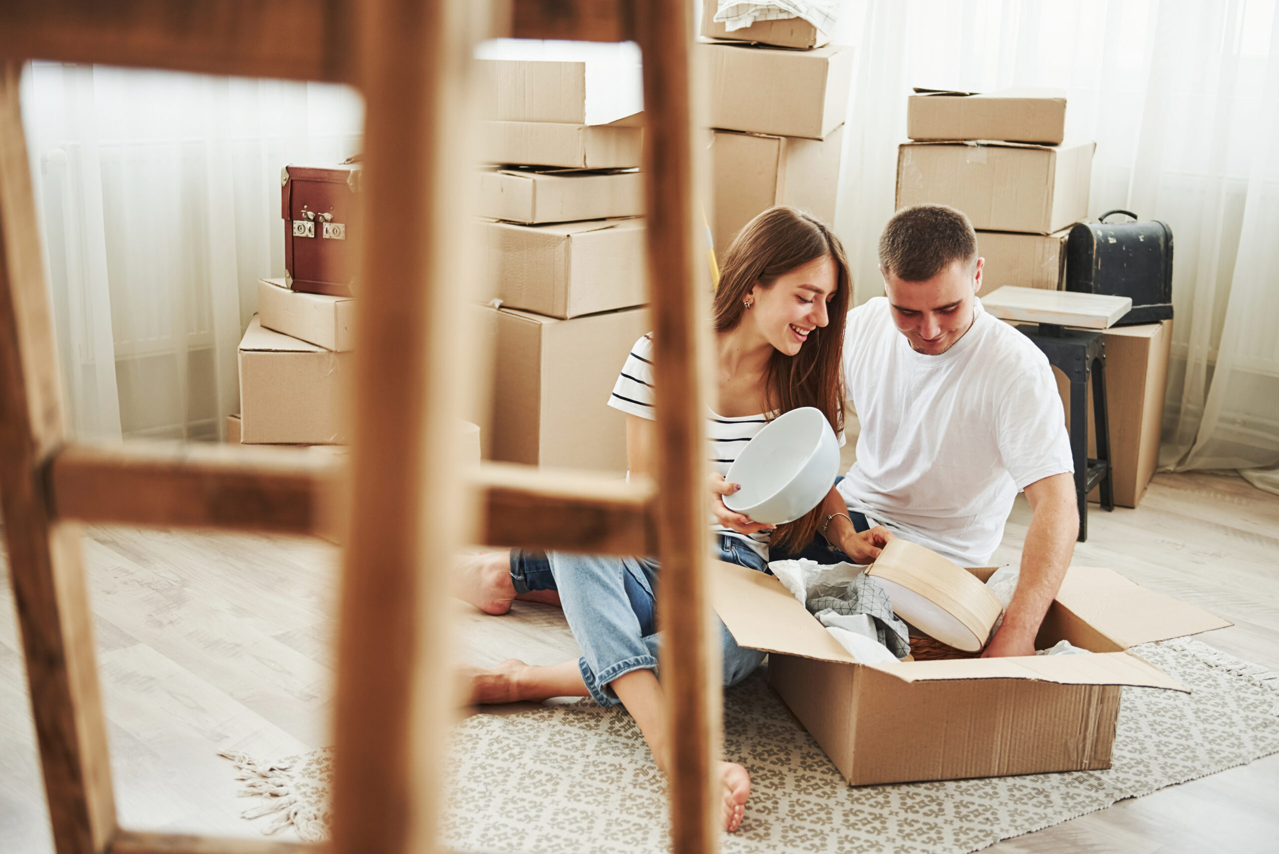 Unpacking boxes. Cheerful young couple in their new apartment. Conception of moving